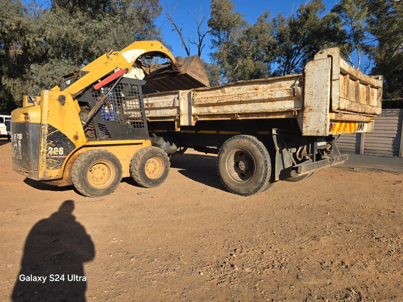 A bobcat Loading a tipper truck